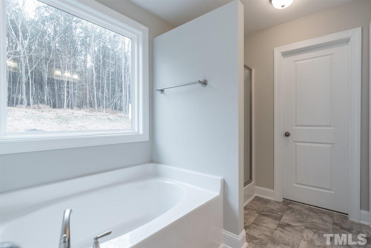 57 Ravencliff Ridge Garner, NC 27529 - Photo 18 of 25 a bathroom with a bathtub and a shower