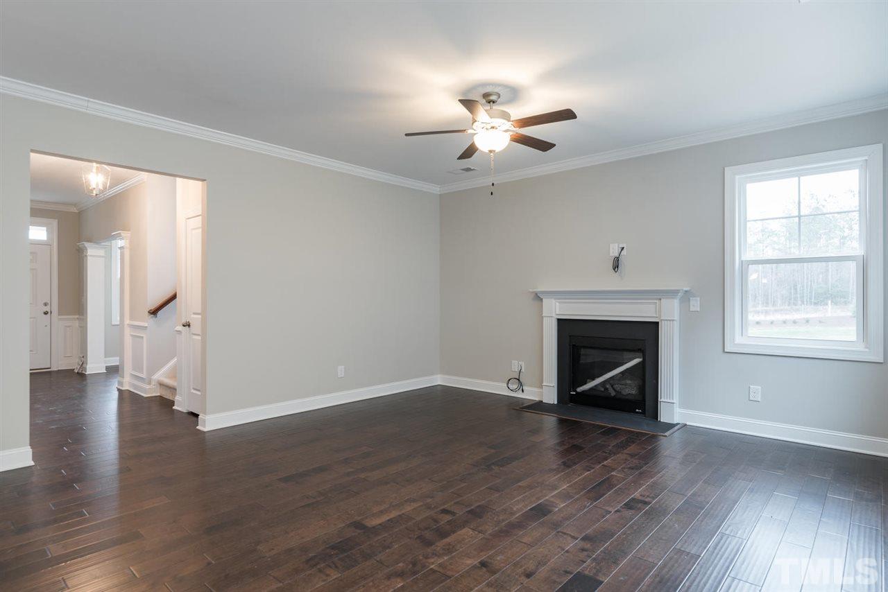 57 Ravencliff Ridge Garner, NC 27529 - Photo 6 of 25 an empty room with wooden floor fan and windows