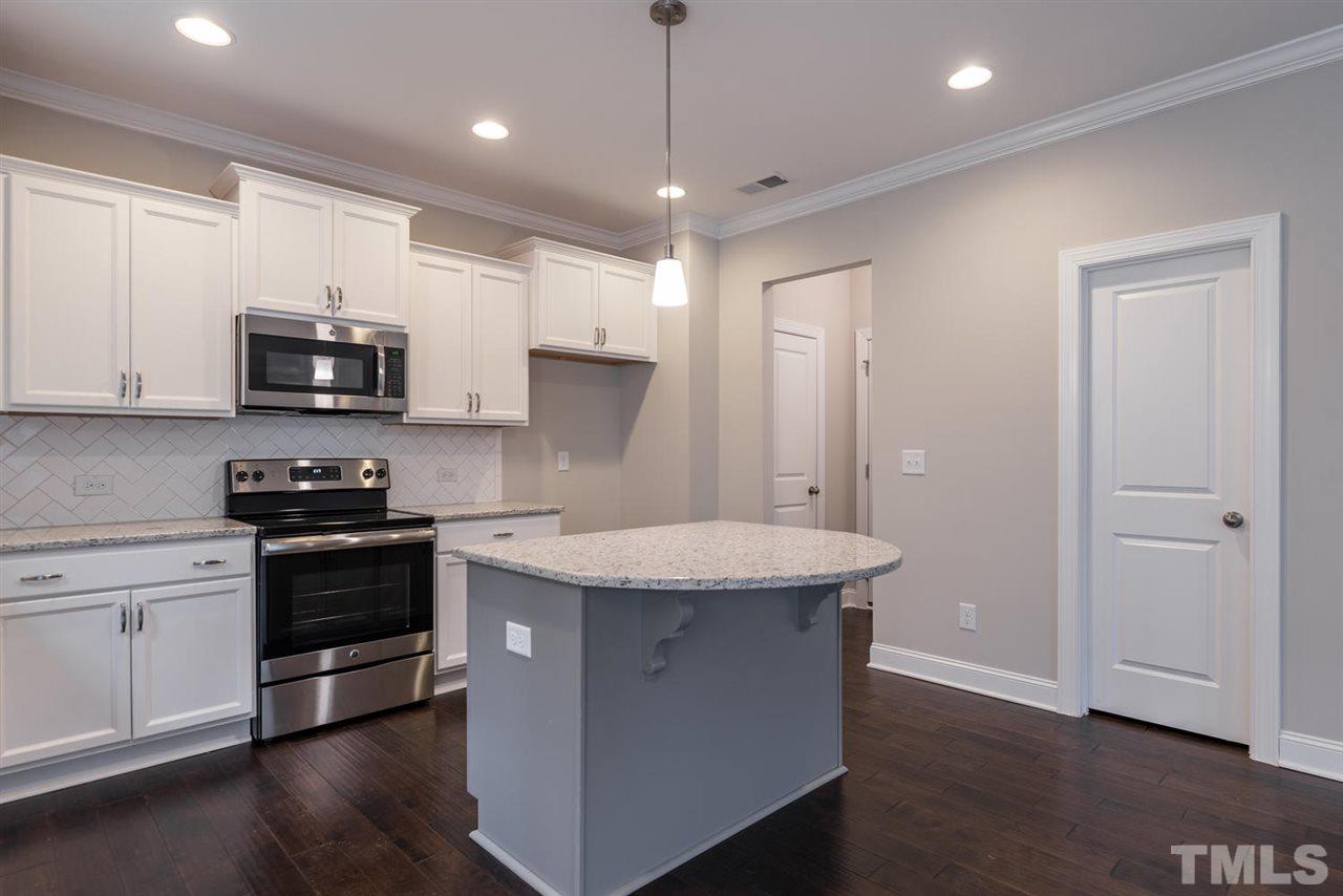 57 Ravencliff Ridge Garner, NC 27529 - Photo 9 of 25 a kitchen with stainless steel appliances granite countertop a stove a sink and a microwave