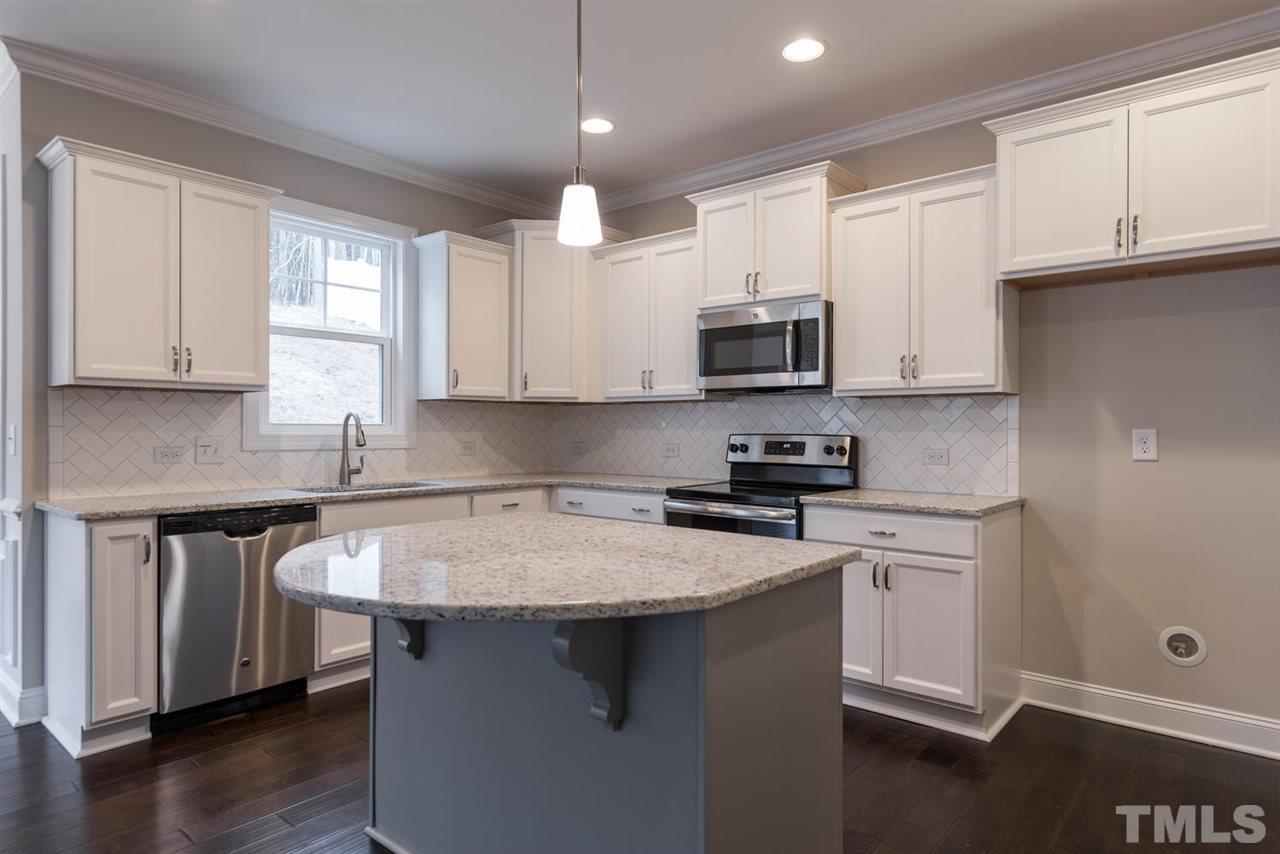 57 Ravencliff Ridge Garner, NC 27529 - Photo 10 of 25 a kitchen with stainless steel appliances granite countertop a sink stove and microwave