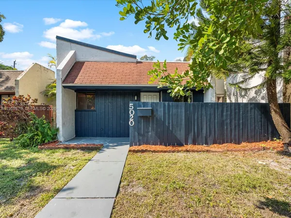 a view of house with backyard and a slide