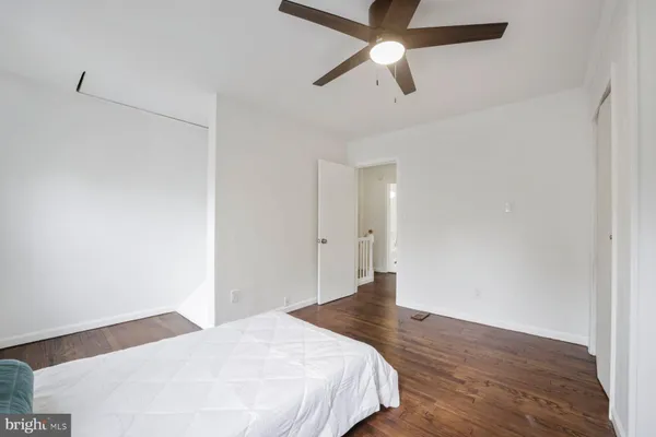 a bedroom with a bed and a chandelier fan