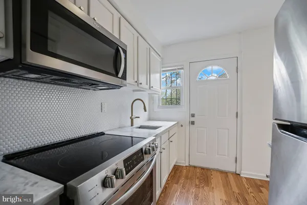 a kitchen with stainless steel appliances a sink a stove a microwave and cabinets