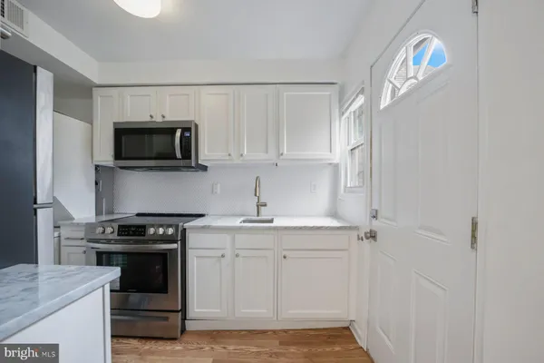 a kitchen with a sink and a stove top oven