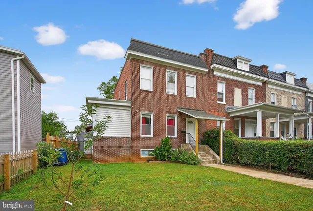 a front view of a house with a yard and plants