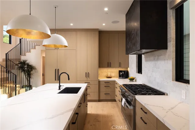 a kitchen with stainless steel appliances a stove a sink and a refrigerator