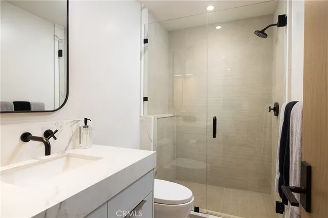 a bathroom with a sink a toilet and mirror