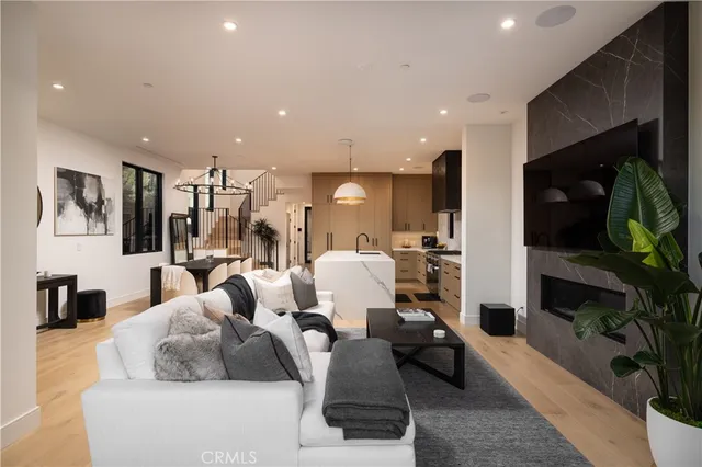a living room with furniture kitchen view and a fireplace