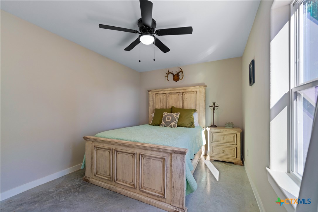 582 Delaware Creek Road Boerne, TX 78006 - Photo 26 of 48 a bedroom with a bed and a table