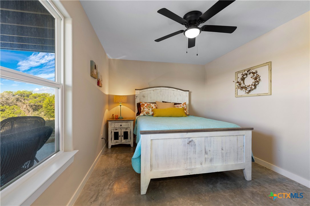 582 Delaware Creek Road Boerne, TX 78006 - Photo 27 of 48 a bedroom with a bed and a tv