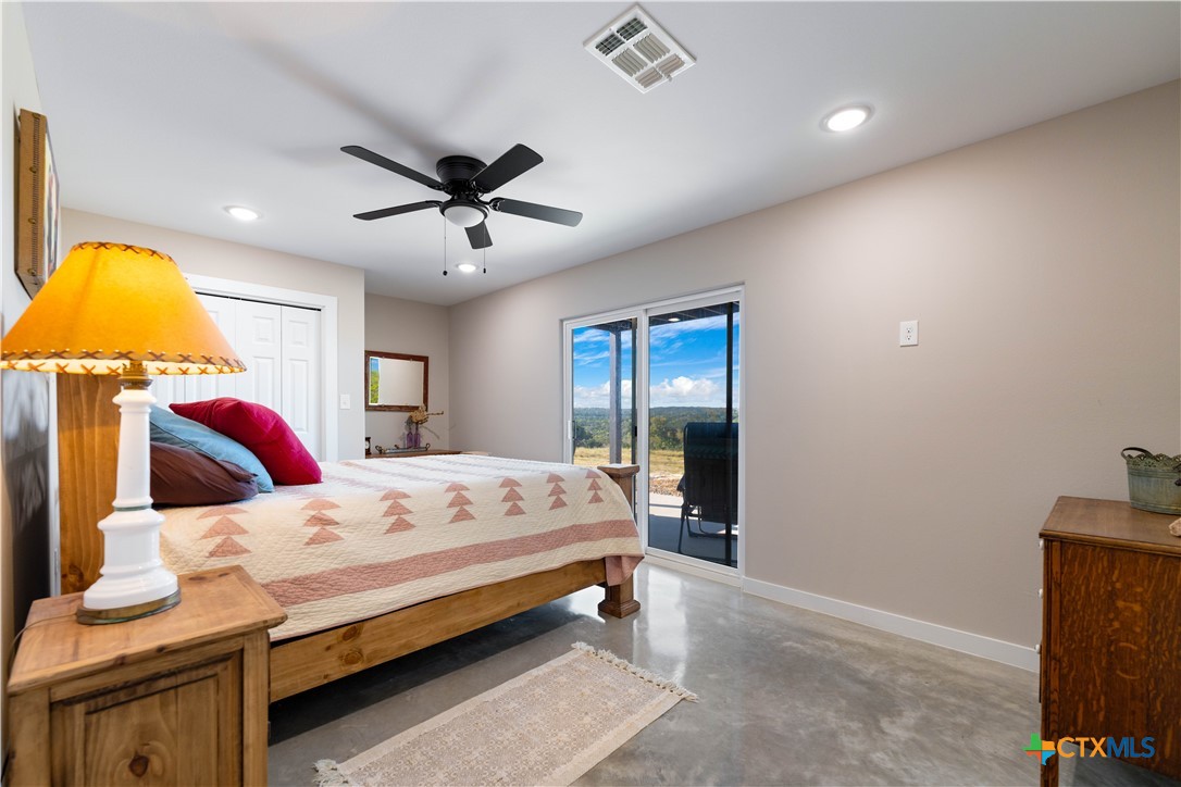 582 Delaware Creek Road Boerne, TX 78006 - Photo 28 of 48 a bedroom with a bed and a chandelier