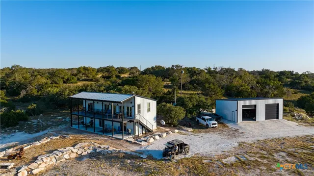 a view of a house with backyard and sitting area