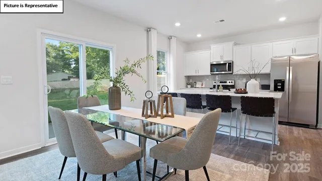 a dining room with furniture a large window and kitchen view