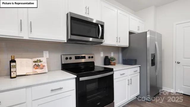 a kitchen with stainless steel appliances granite countertop white cabinets sink and a stove
