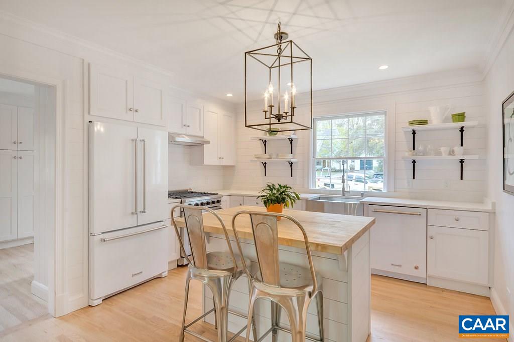 1893 Westview Road Charlottesville, VA 22903 - Photo 7 of 35 a kitchen with stainless steel appliances kitchen island granite countertop a dining table chairs and white cabinets