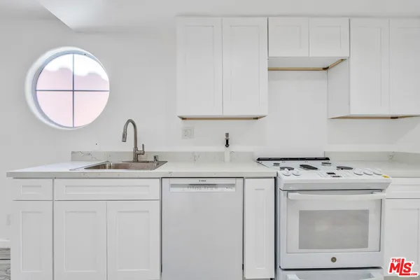 a kitchen with stainless steel appliances granite countertop a sink and dishwasher stove with wooden floor