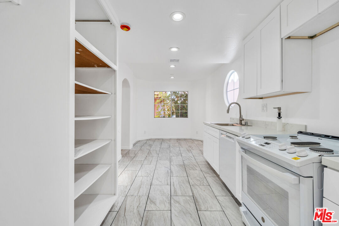 25845 Browning Place Stevenson Ranch, CA 91381 - Photo 20 of 36 a kitchen with stainless steel appliances granite countertop a sink and dishwasher stove with wooden floor