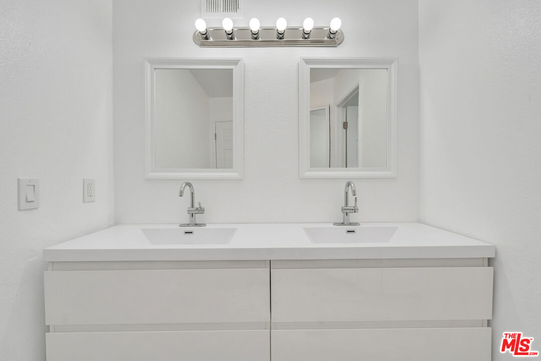 25845 Browning Place Stevenson Ranch, CA 91381 - Photo 24 of 36 a bathroom with double vanity sinks and a mirror
