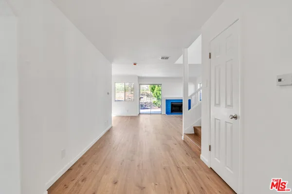 a view of a kitchen with wooden floor and a window