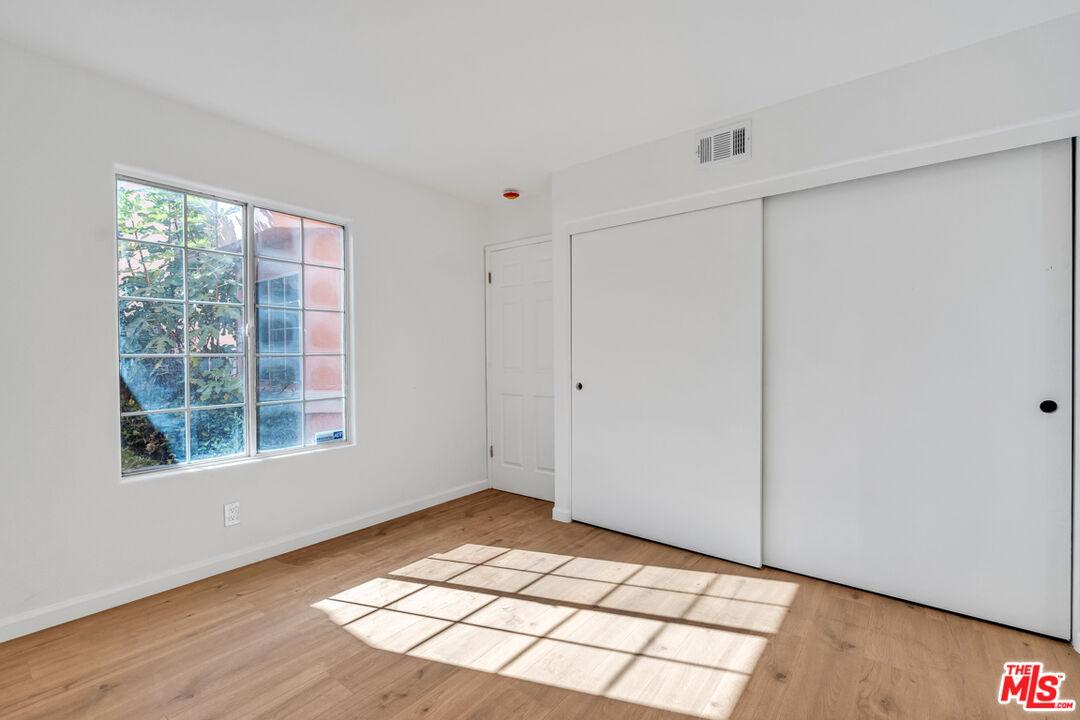 25845 Browning Place Stevenson Ranch, CA 91381 - Photo 10 of 36 a view of an empty room with wooden floor and windows