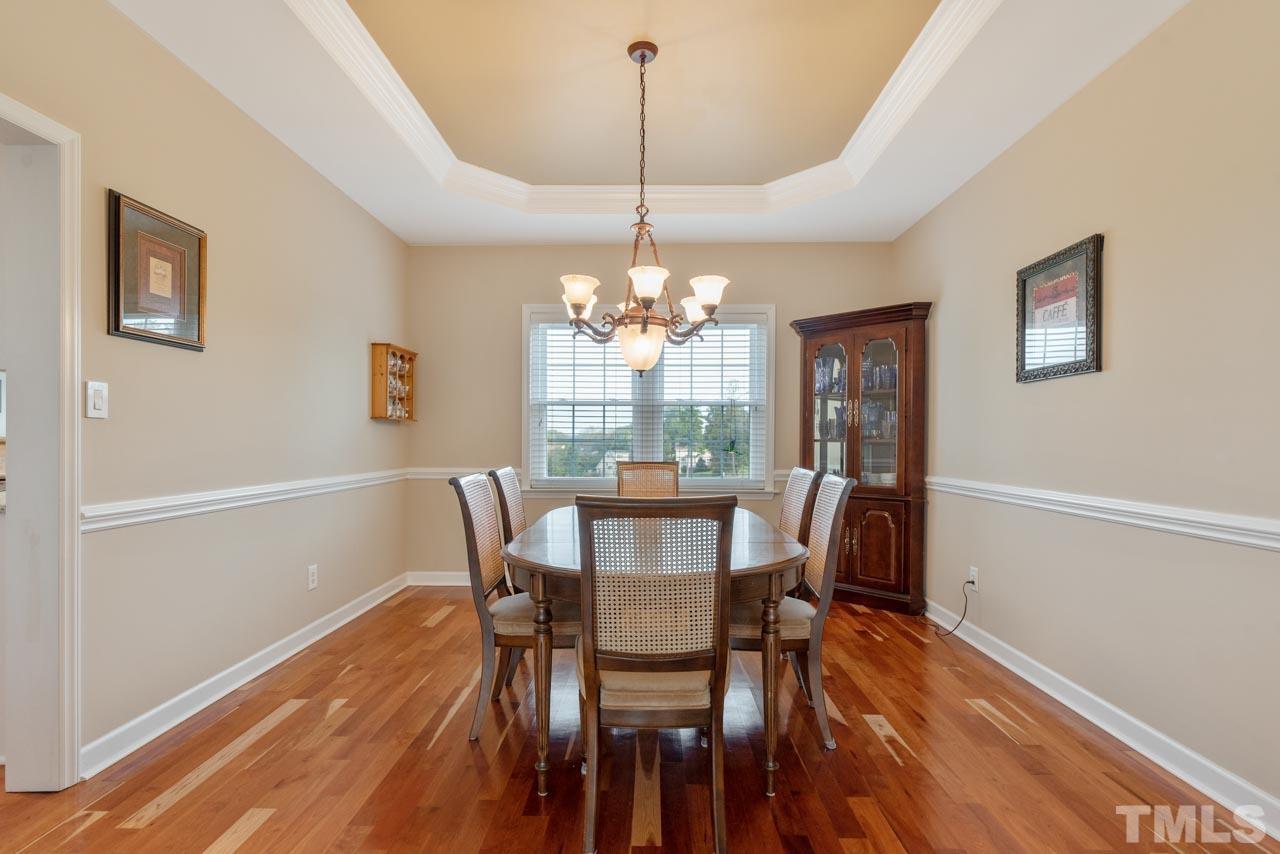 468 Seastone Street Raleigh, NC 27603 - Photo 11 of 28 a dining room with furniture a chandelier and wooden floor