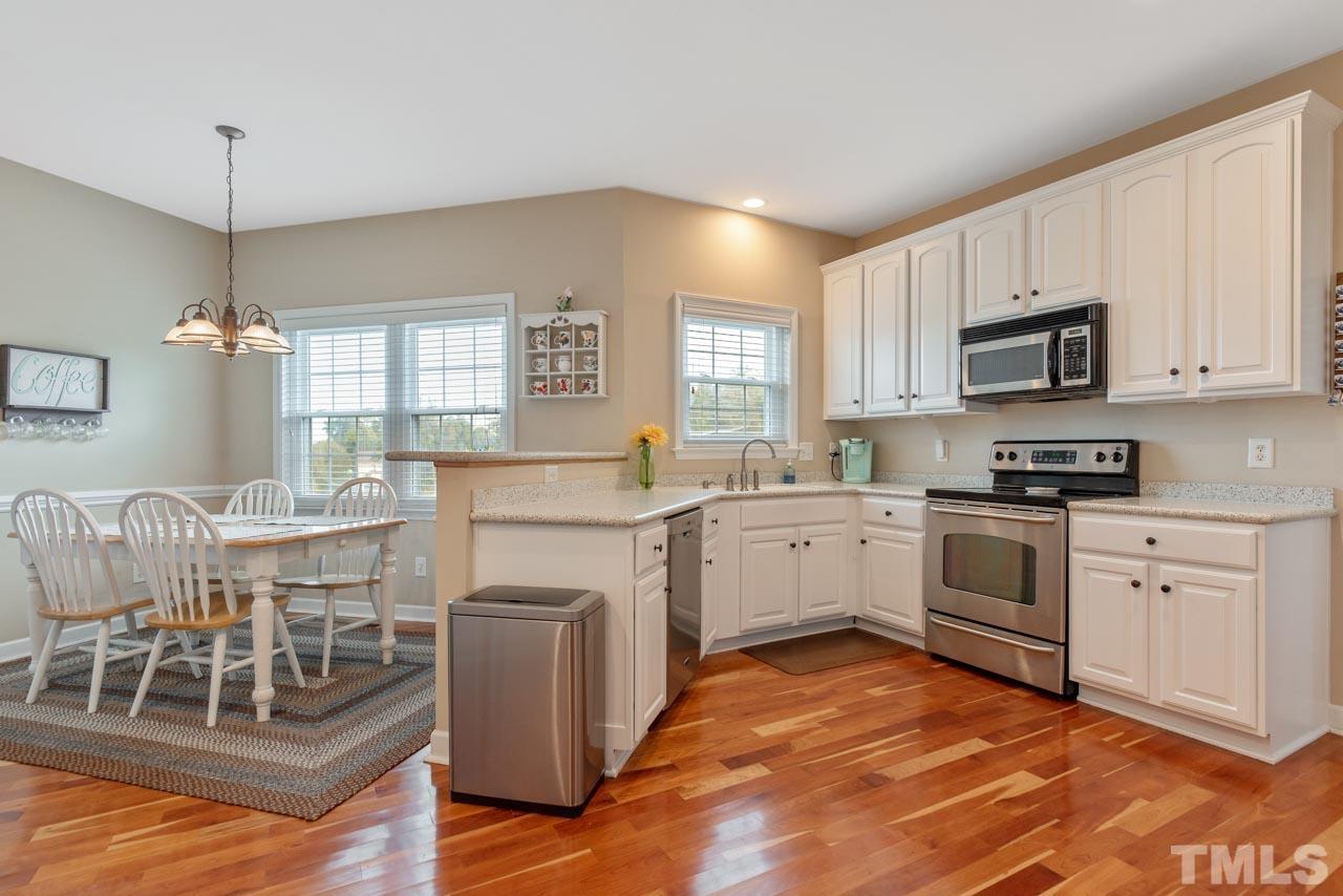 468 Seastone Street Raleigh, NC 27603 - Photo 13 of 28 a kitchen with granite countertop a stove a sink and a refrigerator