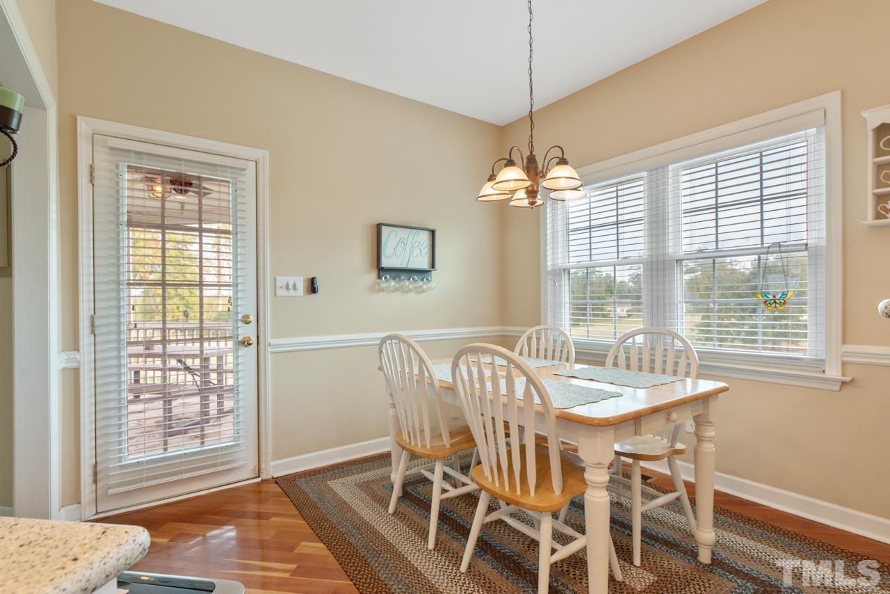 468 Seastone Street Raleigh, NC 27603 - Photo 16 of 28 a dining room with furniture a chandelier and wooden floor