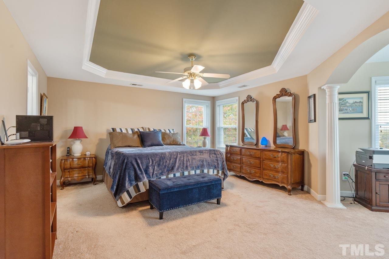 468 Seastone Street Raleigh, NC 27603 - Photo 21 of 28 a spacious bedroom with a bed and a chandelier