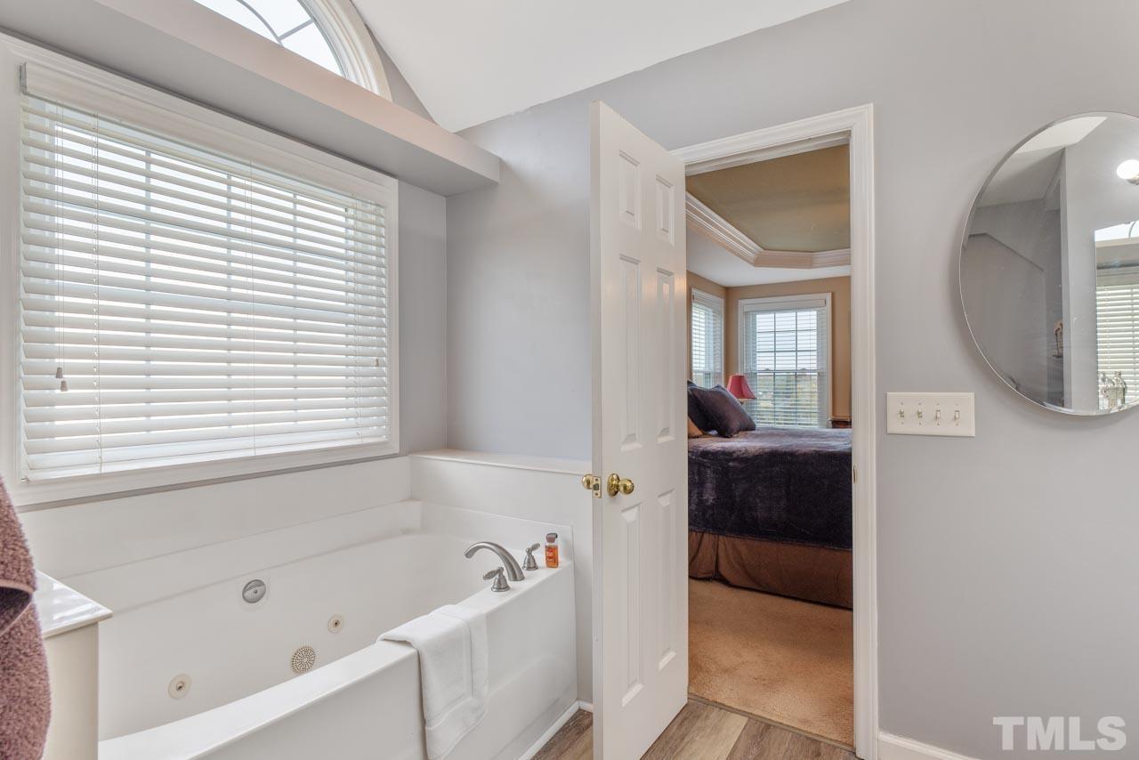 468 Seastone Street Raleigh, NC 27603 - Photo 25 of 28 a bathroom with a tub sink and mirror