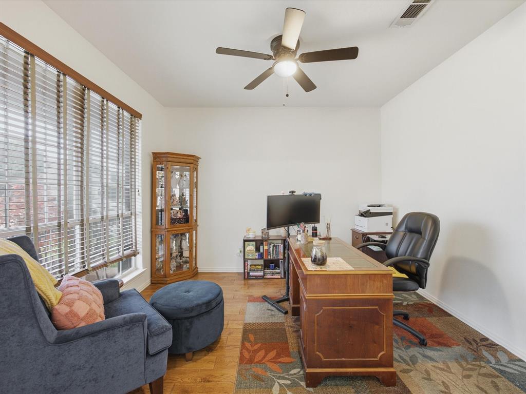 4008 Falcon Ridge Drive Haltom City, TX 76137 - Photo 8 of 40 Spacious room featuring wood-finish flooring, a ceiling fan with integrated lighting, and multiple windows with horizontal blinds