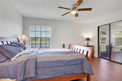 a bedroom with a bed ceiling fan and a window