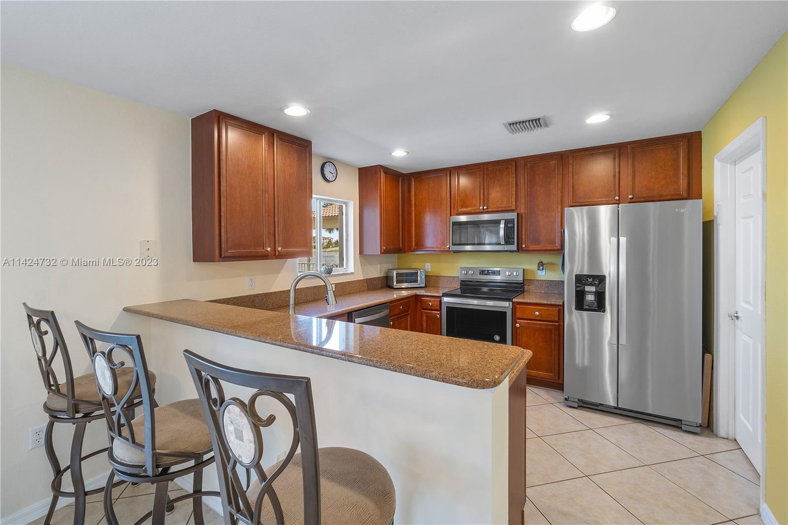 Silver Falls Miramar, FL 33027 - Photo 12 of 49 a kitchen with stainless steel appliances granite countertop a refrigerator a stove a sink a dining table and chairs
