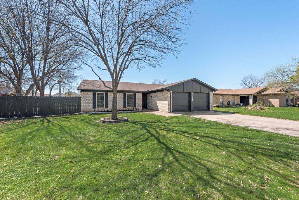 View of front facade with an attached garage, brick siding, concrete driveway, and board and batten siding