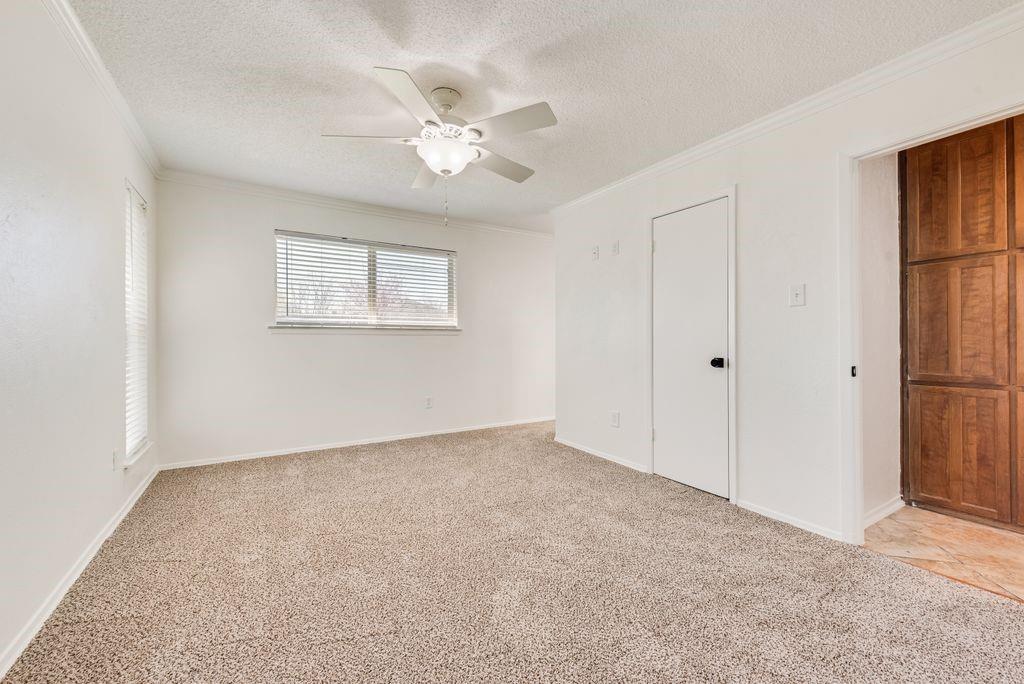 1532 Augusta Road Benbrook, TX 76126 - Photo 17 of 31 Unfurnished bedroom with light carpet, a textured ceiling, ceiling fan, and crown molding