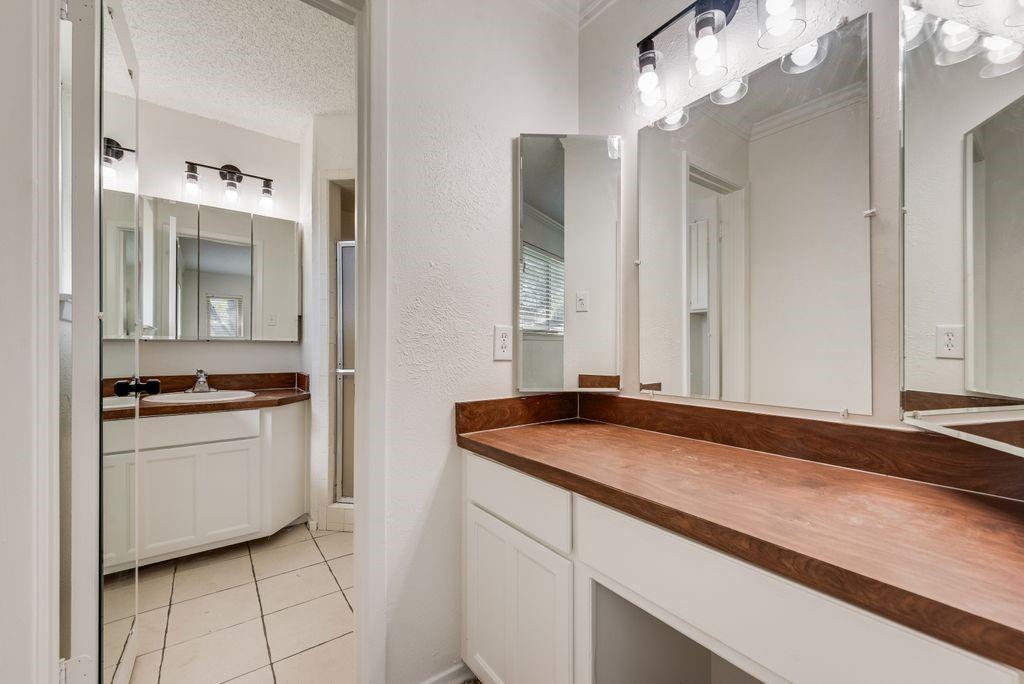 1532 Augusta Road Benbrook, TX 76126 - Photo 18 of 31 Bathroom with vanity, light tile patterned flooring, a textured ceiling, and a stall shower