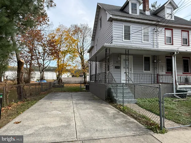 a view of a white house with large windows and a small yard