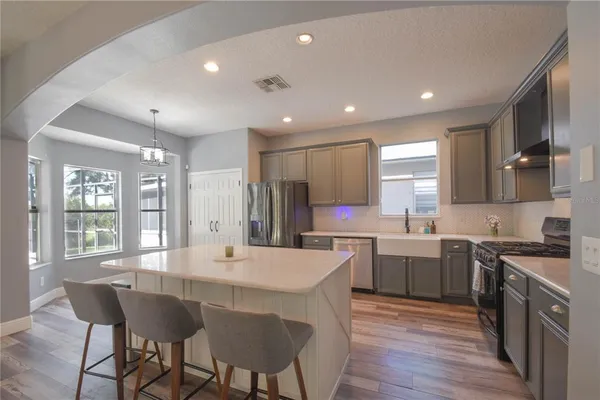 a kitchen with a dining table chairs cabinets and stainless steel appliances
