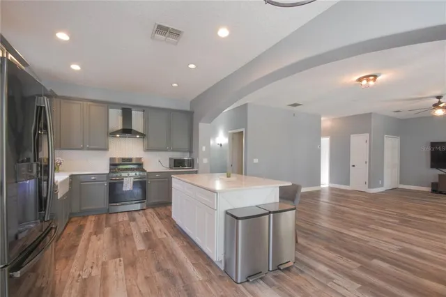 a large kitchen with stainless steel appliances a stove a sink dishwasher and a refrigerator