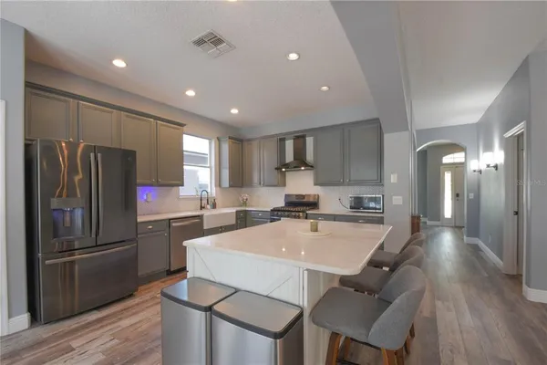 a kitchen with refrigerator and chairs