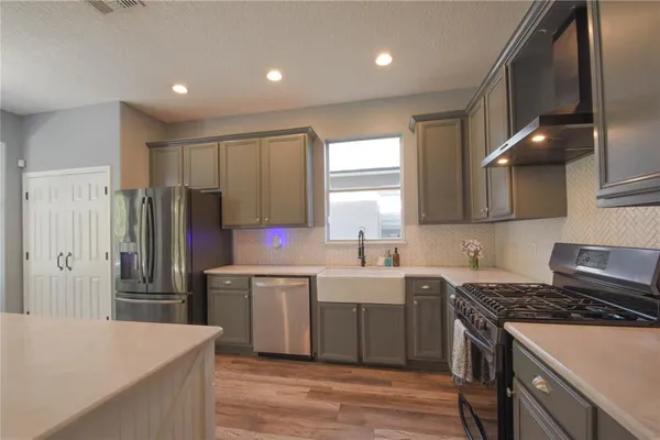 a kitchen with stainless steel appliances a sink stove and refrigerator