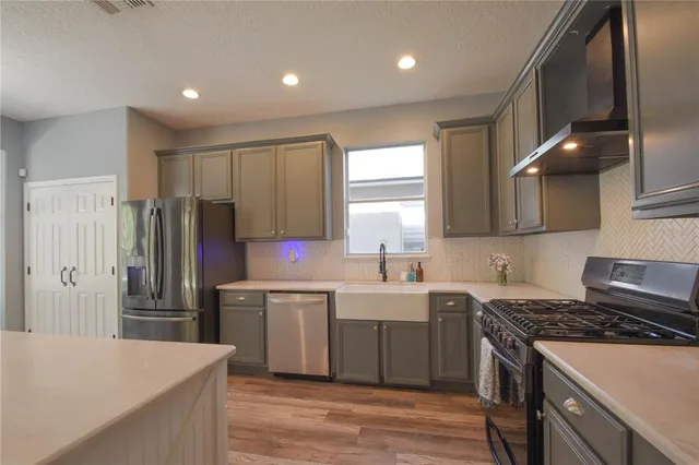 a kitchen with stainless steel appliances a sink stove and refrigerator