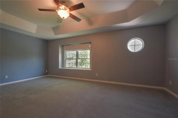 an empty room with a window and a fan