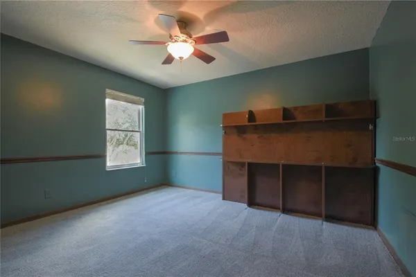 a room with a ceiling fan and a window