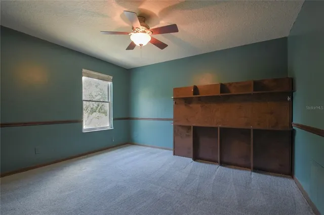 a room with a ceiling fan and a window