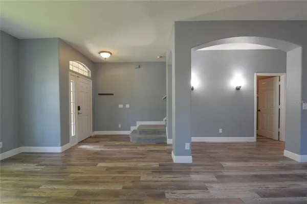 a view of a livingroom with wooden floor and staircase