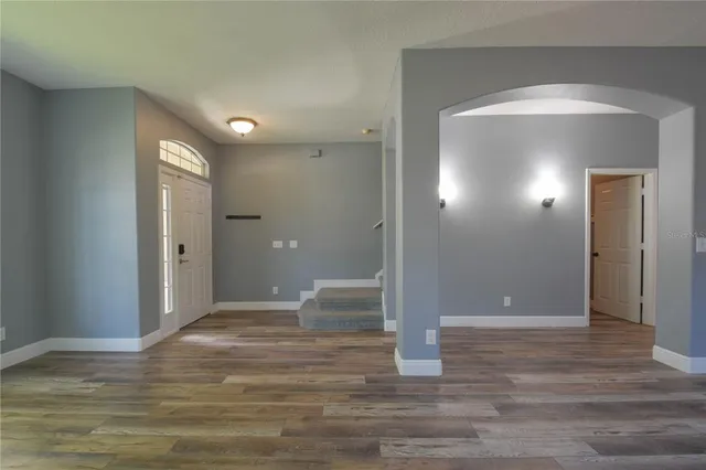a view of a livingroom with wooden floor and staircase