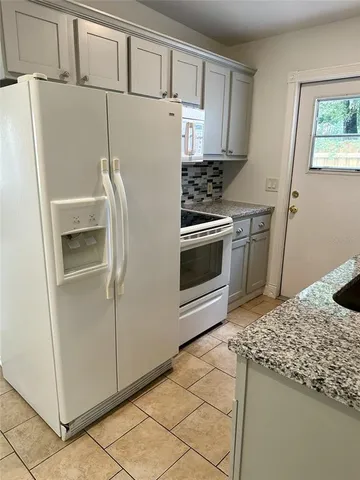 a kitchen with granite countertop a refrigerator and a stove