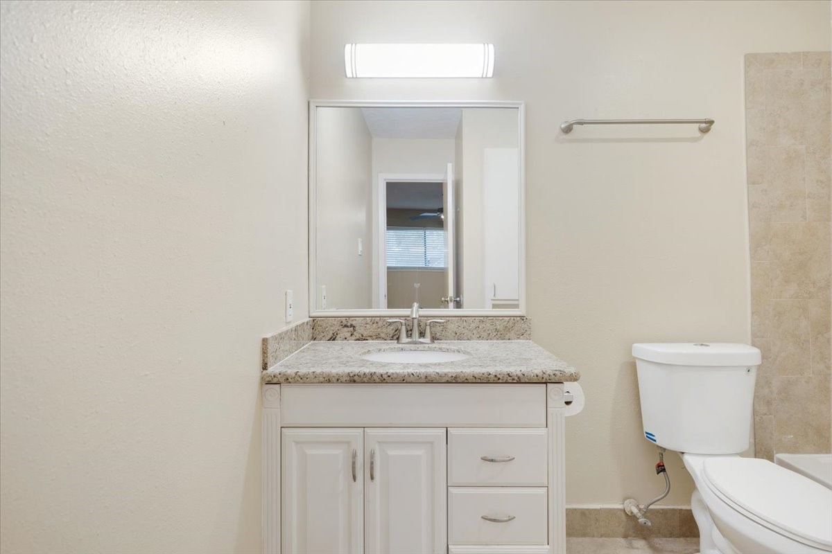 3502 Ocee Street, Unit 3502 Houston, TX 77063 - Photo 11 of 28 This bathroom features a modern design with a granite countertop, white vanity with storage, and a large mirror. The neutral color palette and simple fixtures create a clean, inviting space.