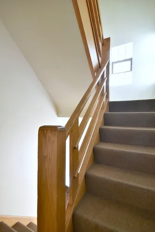 a view of staircase with lots of frames on wall