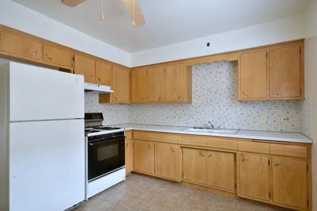a kitchen with white cabinets white stainless steel appliances and sink